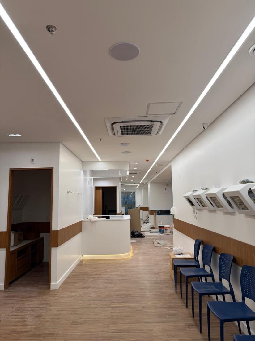 Corredor de clínica com linhas contínuas de perfil de LED no forro